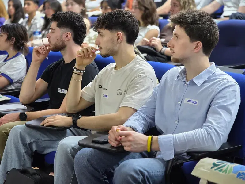 Estudiantes internacionales sentados en el auditorio mientras escuchan las palabras del rector